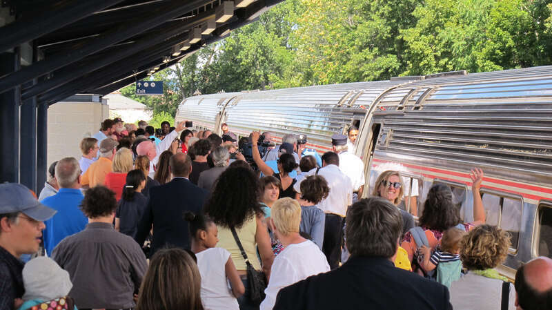 An image of the new Depot Square Railroad Station in Holyoke, Massachusetts on opening day.  The first scheduled Amtrak train, the southbound Vermonter, has just arrived in the station.