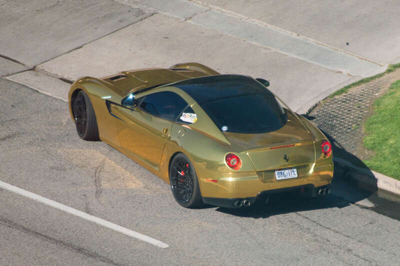 A gold coated Ferrari 599 GTB, part of the 2015 Beehive Drive, while turning left to The Little America Hotel (Salt Lake City), seen from Hilton DobuleTree Suites.