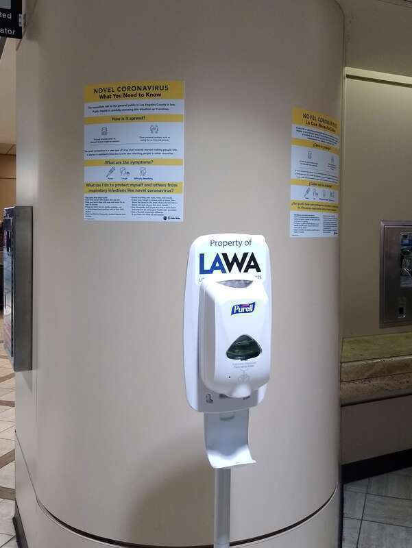 Hand sanitizer and signs about novel coronavirus (COVID-19) at Los Angeles International Airport.