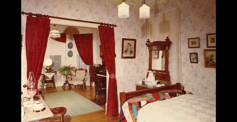 Bedroom of the historical Sproul house in Norwalk, California with view of parlor through door.  House was built by founder of the city, Gilbert H. Sproul.  House was eventually given to the City and turned into a museum.