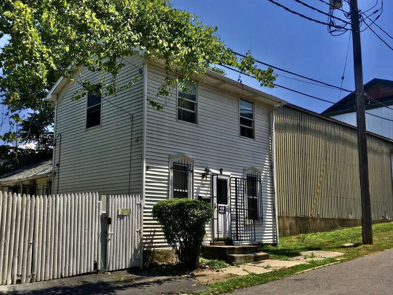 Set incongruously amongst the old warehouses, machine shops and industrial buildings of Buffalo's Upper Black Rock Historic District is the diminutive wood-framed side-gabled house at 19 Mason Street, as seen here in July 2020. The house has no