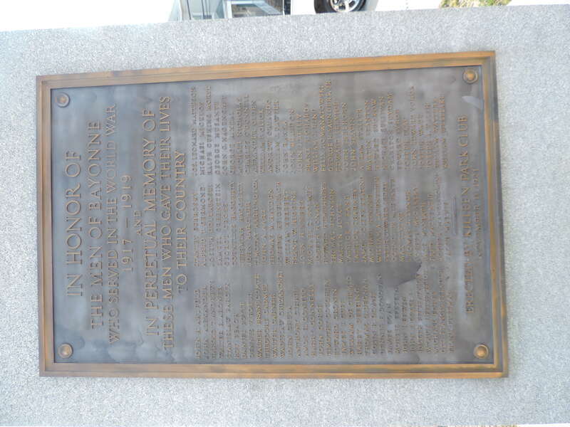 Looking southeast at honor role plaque for The World War on a sunny morning.