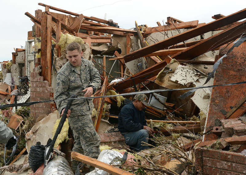 Senior Airman Joshua Jacobs, 146th Air Support Operations Squadron, helps a resident locate his weapons during recovery operations May 21, 2013 in Moore, Okla.  (U.S. Air National Guard Photo by Tech. Sgt. Roberta A. Thompson)
