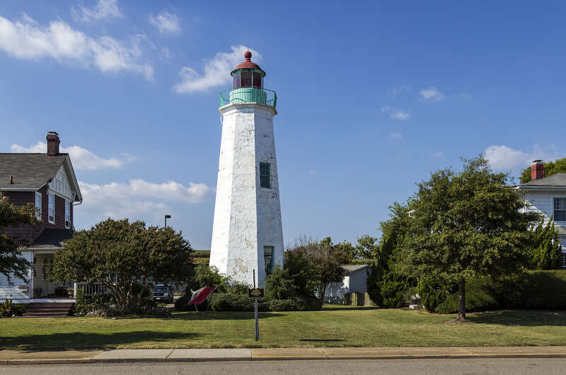 Old Point Comfort Lighthouse, Old Point Comfort Light, in its context between two houses, Fort Monroe, Hampton, Virginia, USA