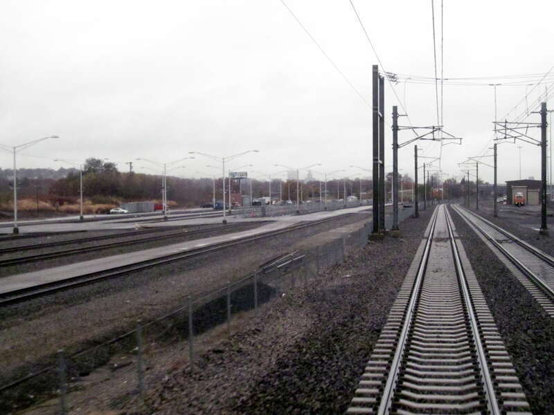 Pawtucket Layover, left, which serves as the primary overnight layover for the MBTA Providence/Stoughton Line. At right are the two tracks of the Northeast Corridor through the area. At far right is a yellow Sperry Rail Service inspection car.