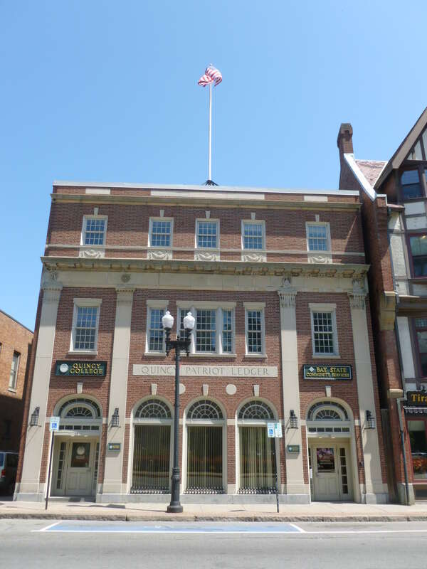 The Quincy Patriot Ledger building, located at 13 Temple Street, Quincy, Massachusetts.  Offices for Quincy College at left and Bay State Community Services at right.