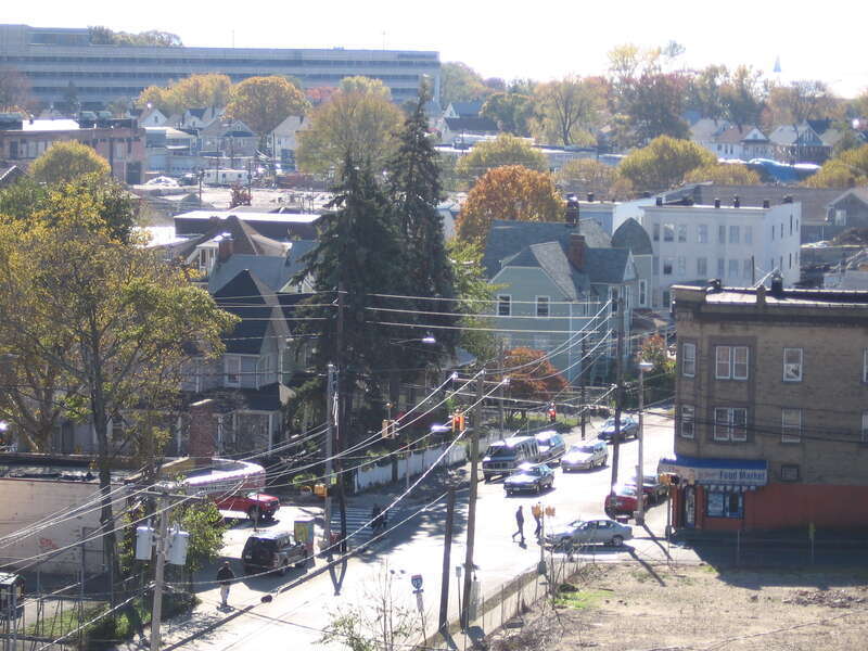 View of Atlantic Street in the South End of Stamford, Connecticut, looking southeast from the Stamford (Metro-North station) parking garage roof. The scene shows typical elements of the neighborhood: the empty lot near the train station, modest old