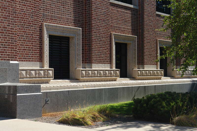 Terra cotta panels around windows and along the water table.