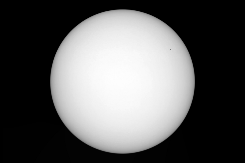 The November 2019 Transit of Mercury.
The featureless Sun, free of sunspots, completely dwarfs the inner planet Mercury. The area of the Sun blocked by Mercury is 26.3 parts per million, or 0.002%. The relative size difference seen here is comparable