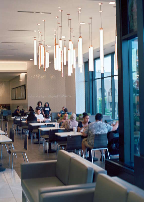A partial view of the farthest usable section of the Dining Pavilion at the Woodfield Mall, which opened in 2017. A prominent glass wall (right) offers diners a northeasterly view of the mall parking lot and various adjacent structures.