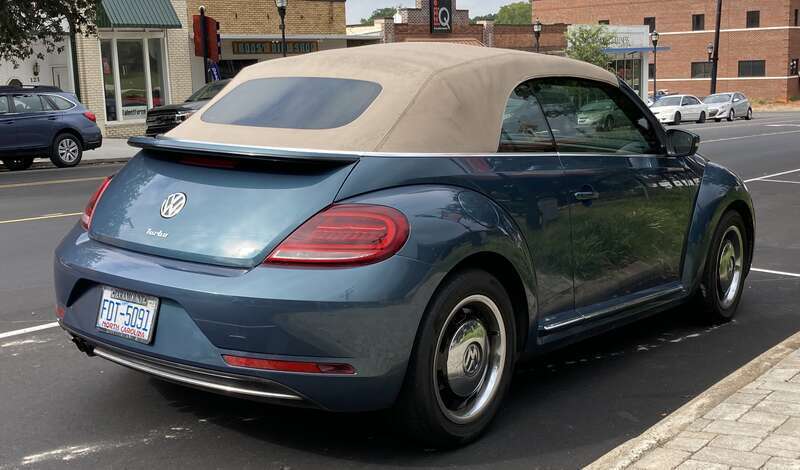 The rear view of a blue convertible Volkswagen Beetle