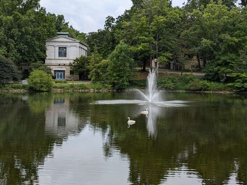 A view of the north wall of Wade Memorial Chapel, across the lank, with a fountain and swans in the background