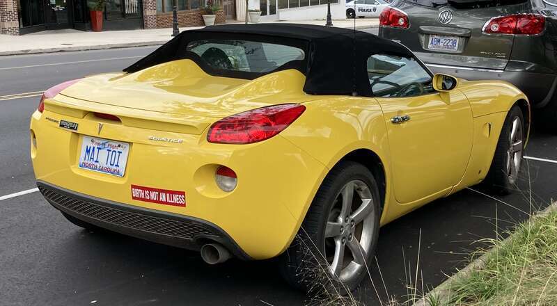 The rear view of a yellow Pontiac Solstice