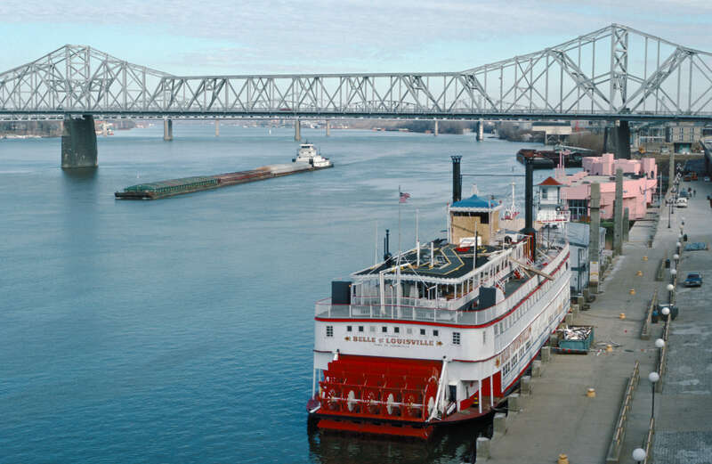 Looking ENE from Belvedere between 4th and 5th Sts.
Steamer &quot;Belle of Louisville&quot; (doc. # 212813) docked at wharf near foot of 4th St.
Pink barges near 3rd St. are Splash bar and Islands restaurant.
Towboat &quot;Dakota Storm&quot; (doc. # 282986) downbound at