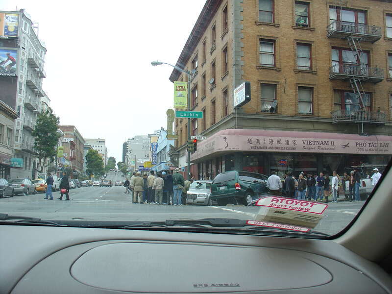 crowd surrounds damaged cars outside Vietnam II restaurant at the corner of Larkin and Ellis Street in San Francisco's Little Saigon, situated in the Tenderloin district
