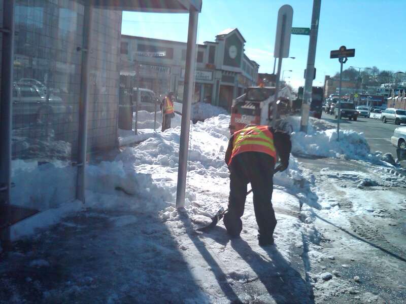 Snow being cleared from a bus stop on Blue Hill Avenue at Woodrow Avenue in January 2011