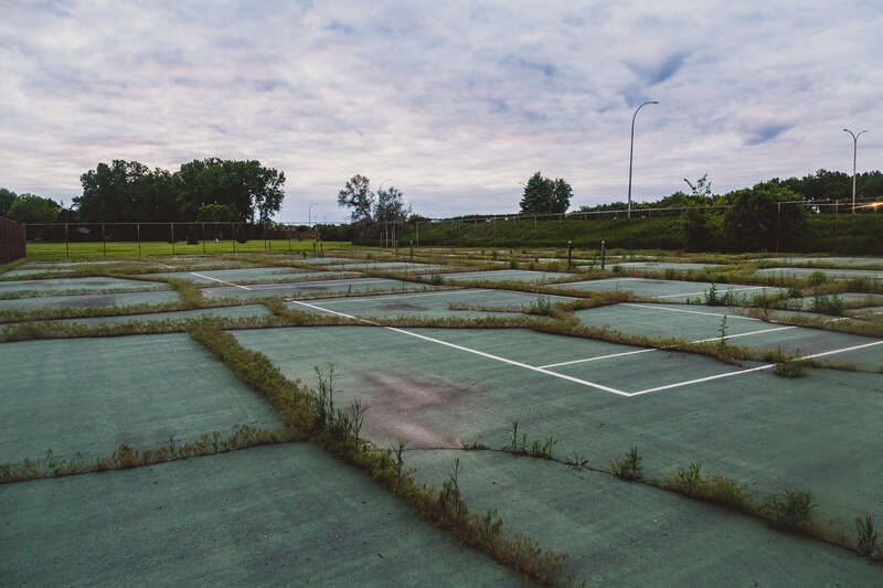 An overgrown tennis court at Centennial Park in Brooklyn Center, Minnesota.