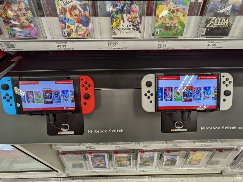 An original image that shows two full Nintendo Switches, the left side is original while the right side is an OLED model, with games on top and bottom of the demo Switches in a Target store in Walnut Creek.
