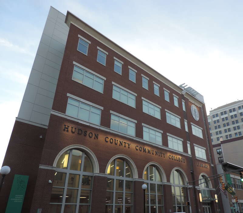 Looking southwest across Sipp Avenue at Hudson County Community College Library near dusk of a mostly sunny day