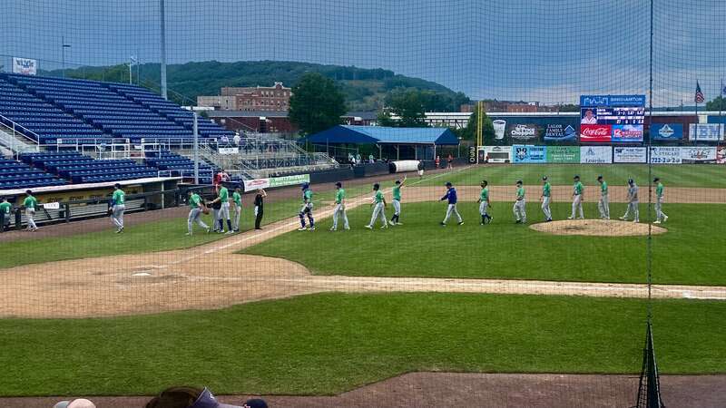 As encroaching clouds threaten rain overhead, the Hartford Yard Goats walk off the field after a 10-6 road victory over the Binghamton Rumble Ponies at Mirabito Stadium on a July 2022 afternoon.