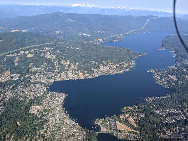Aerial view of Lake Whatcom, with Mount Baker in the background.  The black curve in the upper right is a propellor blade, distorted by rolling-shutter artifact.
