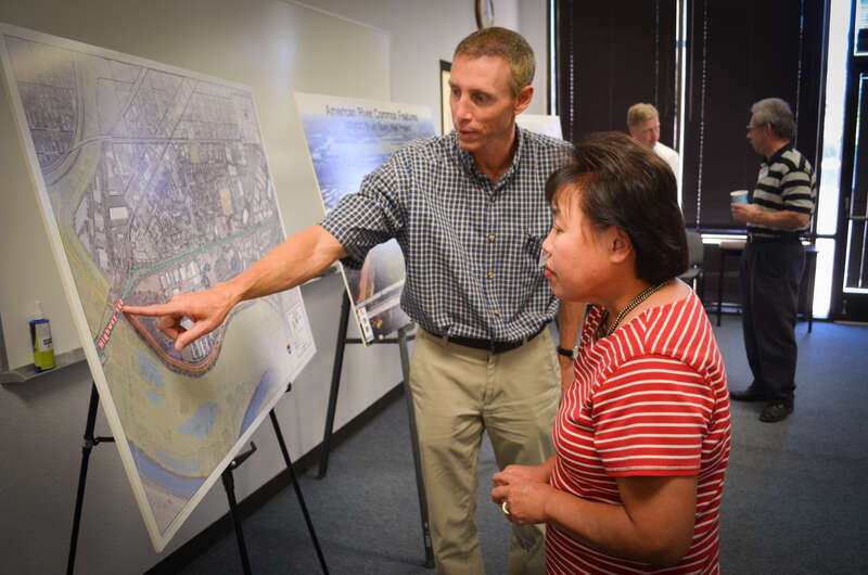 Mark Boedtker (left), an engineering technical lead for the U.S. Army Corps of Engineers Sacramento District, spoke with nearby resident Vicki Kawamura about upcoming levee work along the American River, during a public meeting in north Sacramento,