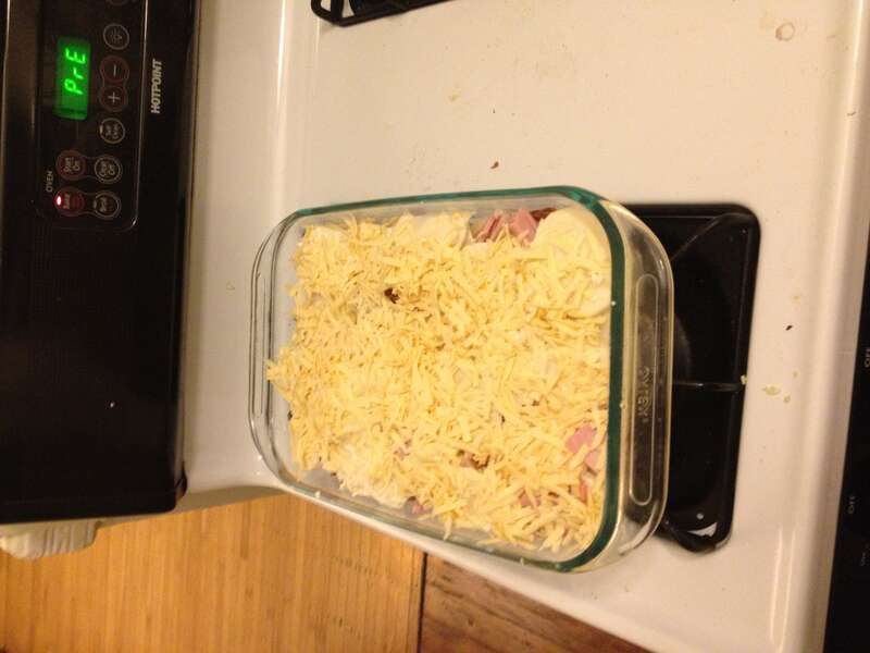 Homemade potato gratin with Gouda cheese and ham mixed in, before baking.