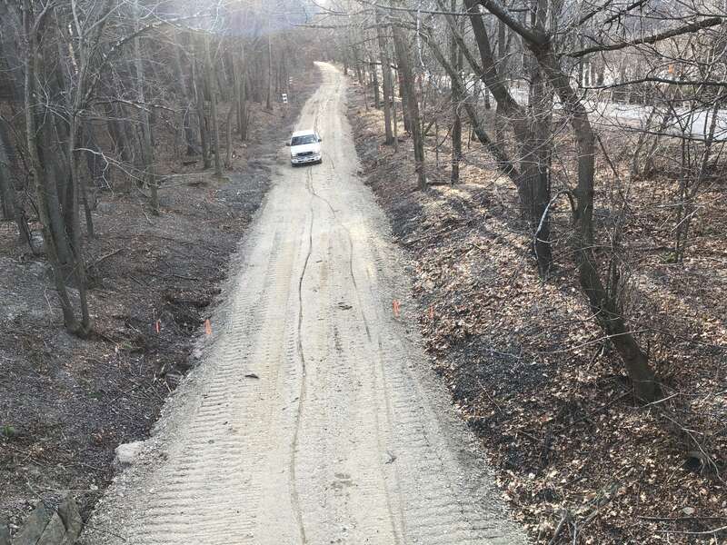 Watertown-Cambridge Greenway path under construction, showing temporary access road with a car on it. Taken facing south from overpass at entrance to Water Treatment Plant parking lot.