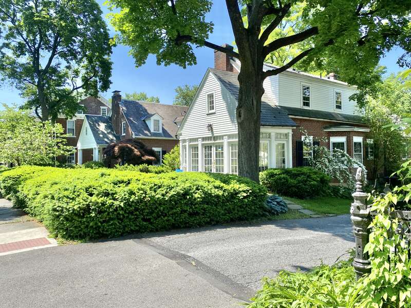 Built in 1940, these Colonial Revival-style houses face towards a shared courtyard and feature red brick exteriors, side gable roofs, six-over-six and eight-over-twelve double-hung windows, three gabled roof dormers on the front, large shed dormers