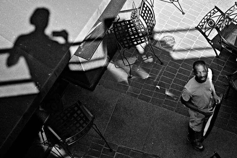 500px provided description: I took this photograph on a street photography tour with my son in downtown Dallas. I am peering into a subterranean restaurant called Dakota's. This kind gentleman is answering one of my inane questions which typically