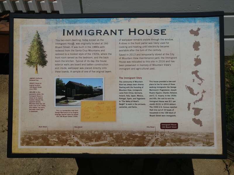 A panel explaining history of the &quot;Immigrant House&quot; structure displayed within the park.