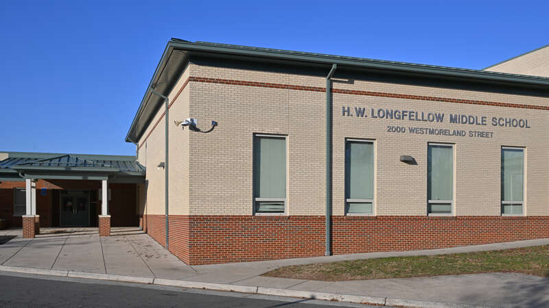 The red and white brick building for Henry Wadsworth Longfellow Middle School and one of the entrances to it. Longfellow M.S. is part of Fairfax County Public Schools. 2000 Westmoreland Street, Falls Church, Virginia 22043.