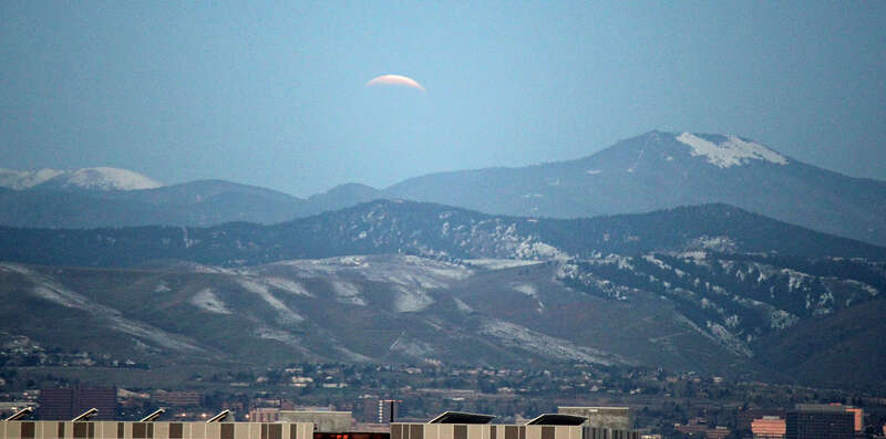 The lunar eclipse of April 4, 2015. The view is from downtown Denver looking west towards the Front Range mountains. The mountain on the right is Squaw Mountain. The picture was shot about a half hour after totality ended.