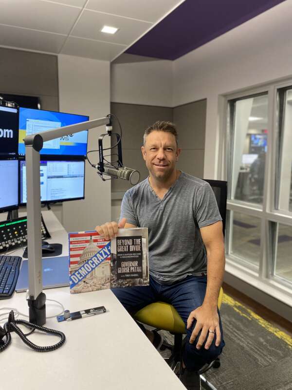 Radel signing his two books, Democrazy and Beyond the Great Divide