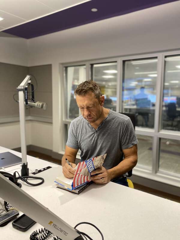 Radel signing his books, Democrazy and Beyond the Great Divide