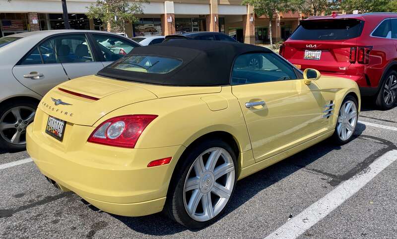 2005 Chrysler Crossfire roadster finished in yellow with black fabric top. Photographed September 2024 in Bowie, Maryland.