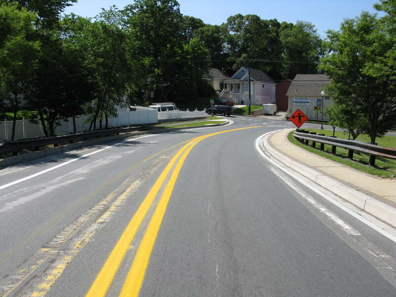 MD 564 approaching 11th Street, Bowie, Maryland.  The markings along the bridge were removed (by grinding) the previous day.  New markings were applied earlier in the morning.  The final configuration shifted westbound traffic (away from the camera)