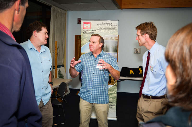 Brain Mulvey (center) and Steve Osgood (second from right) with the U.S. Army Corps of Engineers Sacramento District, discusses potential environmental impacts from riverbank erosion repairs during a public workshop in Chico, California Feb. 4, 2015.