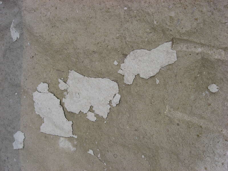 Pieces of stone flaking off the top of a block of limestone at a patio on the northern side of the Indiana Memorial Union.