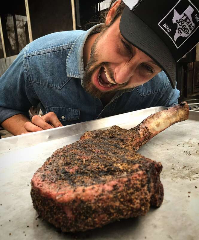 La BBQ pitmaster Brendan Lamb about to eat a giant tomahawk steak at the Austin restaurant.