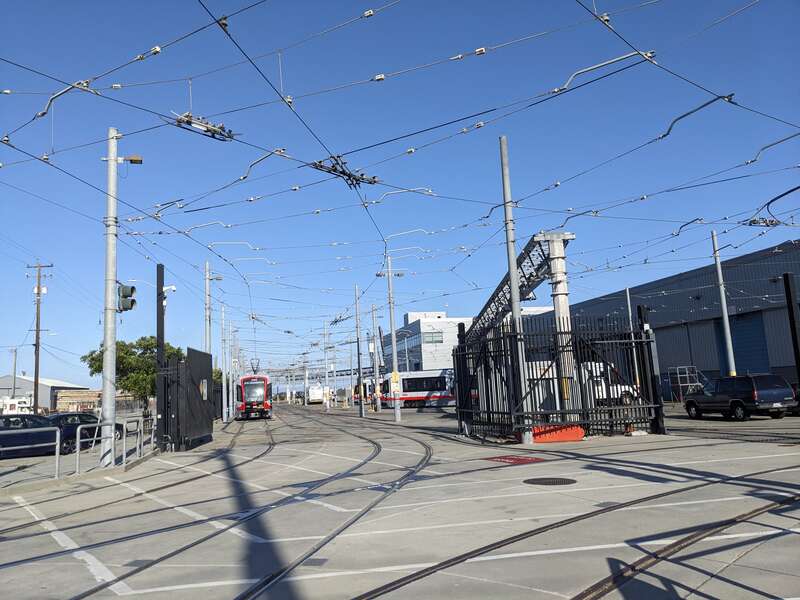 During a bike ride, I saw several Muni trains, including car 2151 that was recently delivered, and a bus.