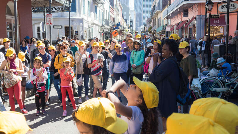 Une rue du vieux carré avec une chanteuse entourée d'une foule pendant le French Quarter Festival 2019