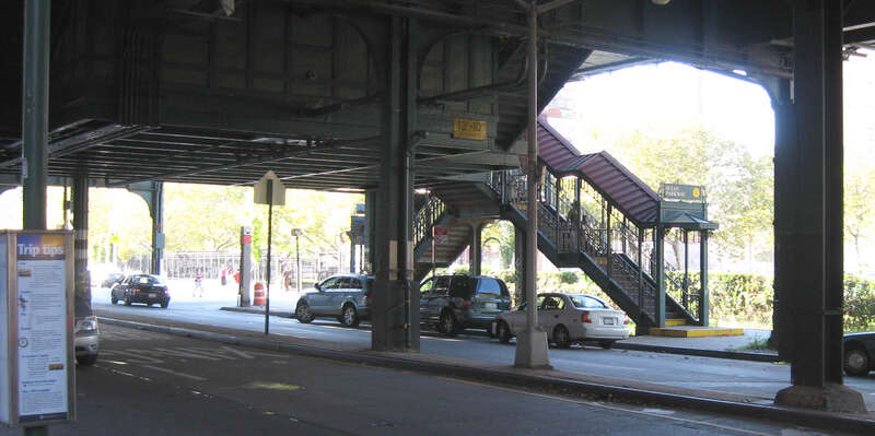 Looking north across Brighton Avenue, underneath the Brighton Line at en:Ocean Parkway (BMT Brighton Line) station stair on a sunny afternoon