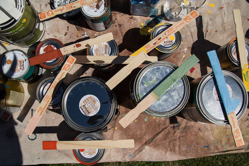 Brushes, stirrers and paint cans sit ready for use at a mural painting at Perkins Elementary School.