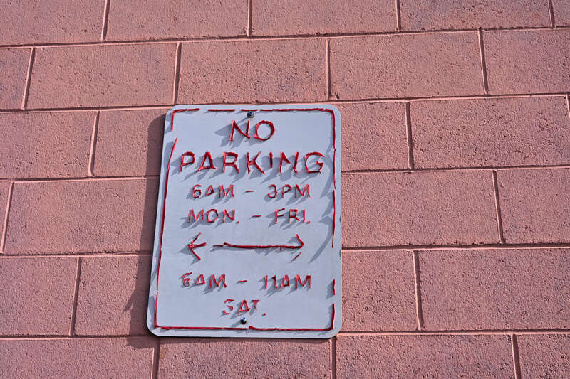A "no parking" sign at the Market Basket grocery store in Somerville, Massachusetts, with the lettering peeling off