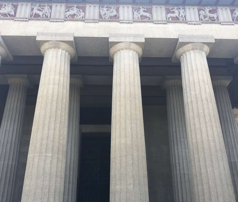 The photo shows part of the doric columns and the outer frieze of the Parthenon at Centennial Park, Nashville, Tennessee