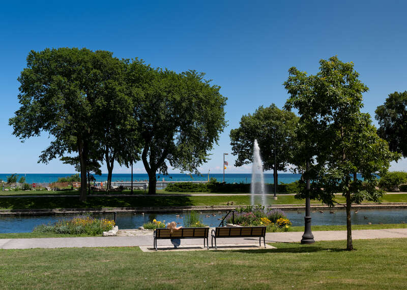 Women sitting on a bench near Arrington Lagoon at Dawes Park, Evanston, Illinois, US