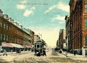 Divided back postcard of a streetcar on Essex Street in Lawrence, Massachusetts, postmarked 1911. The building at right is 296 Essex Street, with a sign for C.E. and H.J. Bradley Real Estate.