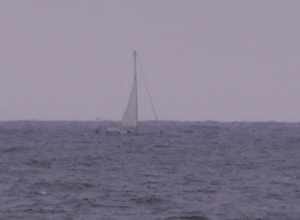 Sailboat being bounced around by waves in the Atlantic Ocean off of Asbury Park, NJ.  You can hardly see the boat for the waves.  He had four cop cars, four fire engines and 2 ambulances following him.  Wouldn't a coast guard boat or perhaps a
