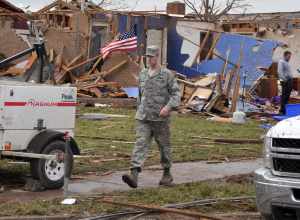 An Air Force member moves through a neighborhood looking for people in need of help in the aftermath of the devastating tornado that ripped through Moore Okla., May 20, 2013. One of the hundreds of Oklahomans to lose their homes is being interviewed